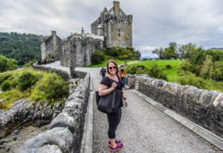 Louise Connolly stands before the cinematic Eilean Donan Castle, Scotland